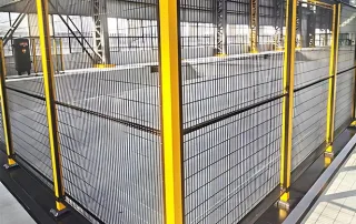 Cercado de proteção com malha preta em torno de uma célula de trabalho pesada Mdfence para controle de projeção de sucata e colisão