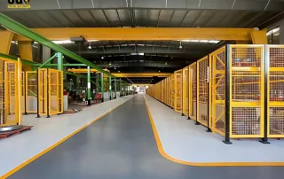 painéis de cerca de proteção de máquinas em um corredor de armazém com proteção perimetral modular Mdfence amarela