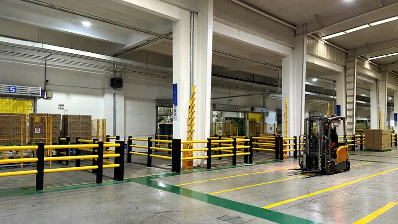 Self-Rebounding Barrier in a warehouse forklift aisle, protecting loading bays and columns with floor-mounted modular rails