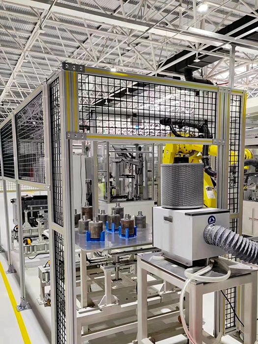 Machine guard fencing: Industrial wire mesh safety enclosure with a yellow robot, component fixtures, and flexible dust extraction ducting
