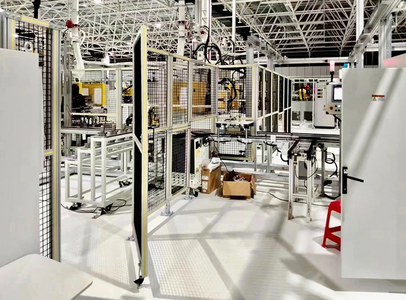 Cella robotizzata industriale racchiusa da recinzione di sicurezza modulare in rete metallica con cancelli di accesso a cerniera e pannelli di controllo per recinzione di isolamento attrezzature