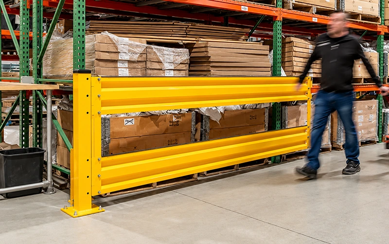 Corrugated guard rail protecting pallet rack ends with bolted base plates