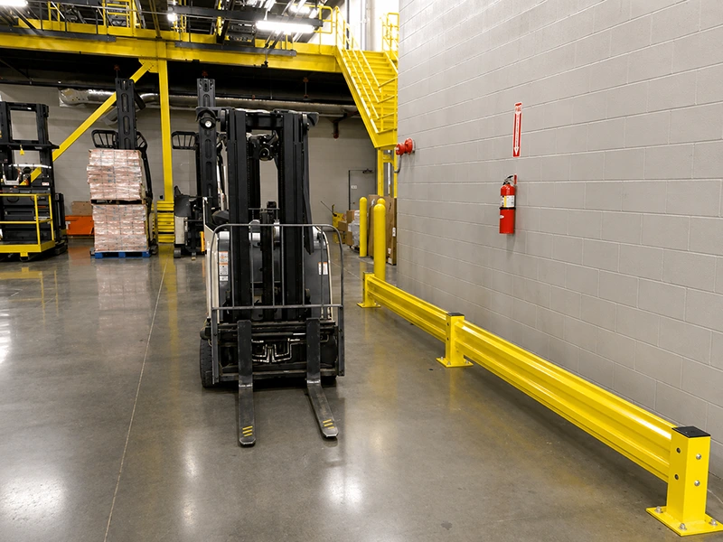 industrial guard rail protecting a warehouse wall beside forklift and pallet operations